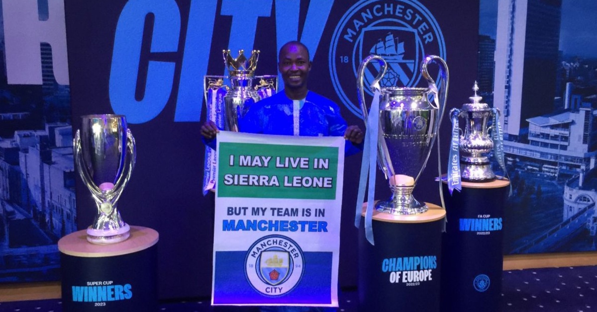 Sierra Leonean Man City Fan, Armani, Poses with Club’s Trophies